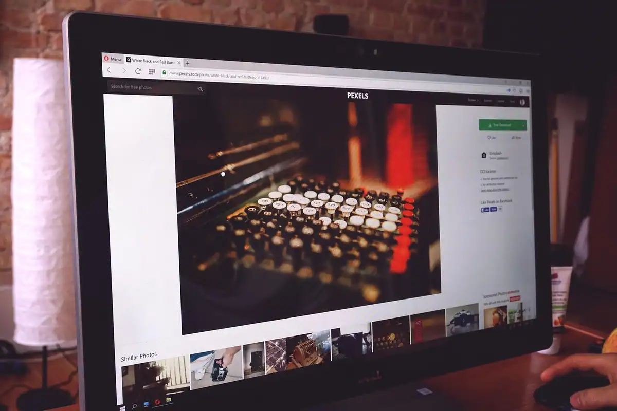 Monitor pe care e deschisă o fotografie într-un program de editare, pe un birou