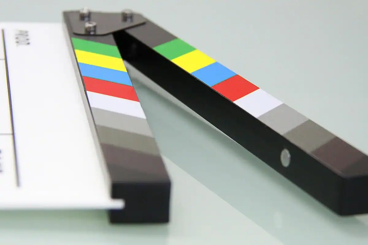 Claqueta de film cu dungi colorate, așezată pe o masă luminoasă
